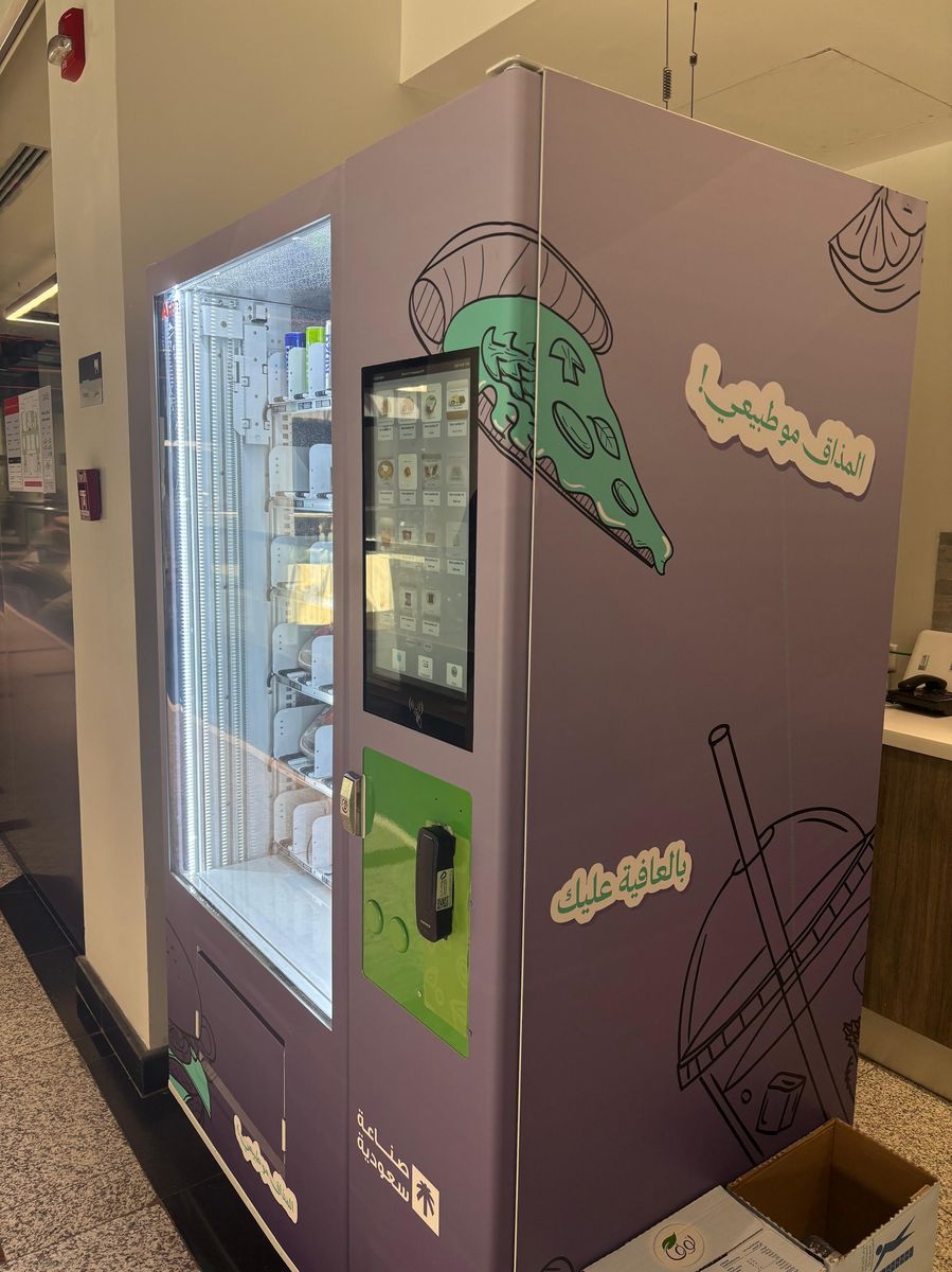 Side view of branded vending machine — المذاق مو طبيعي — صناعة سعودية